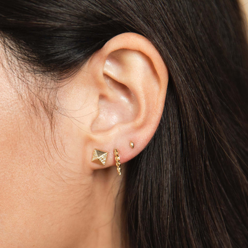 woman's ear wearing a Zoë Chicco 14k Gold Spiked Hinge Huggie Hoop Earring