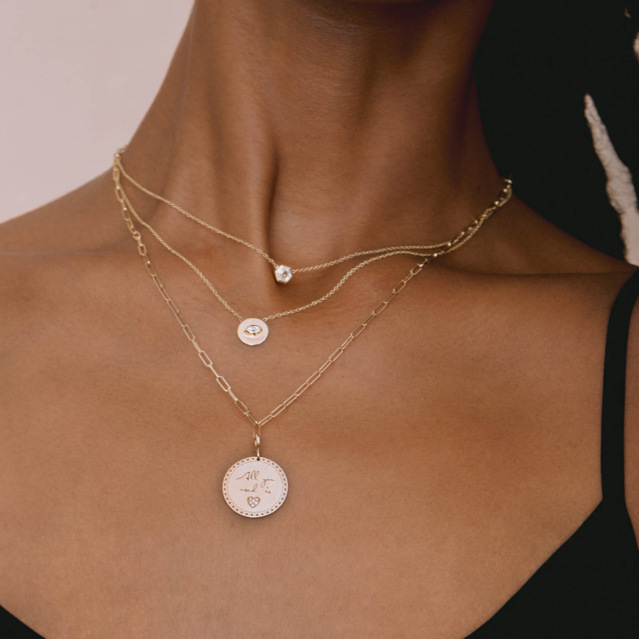 woman in black camisole top wearing a Zoe Chicco 14 karat gold Medium Mantra with Heart Border Disc Charm Pendant on a paperclip chain necklace