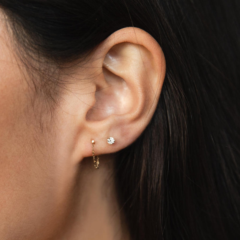woman's ear wearing a Zoë Chicco 14k Gold Square Bead Chain Huggie Earring layered with a diamond stud