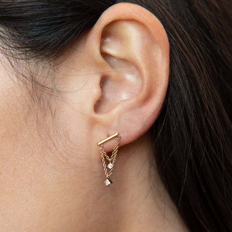 close up of a woman's ear wearing a Zoë Chicco 14k Gold Bar & Mixed Diamond Double Chain Drop Earring