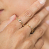 woman resting her hand on her face while wearing a Zoë Chicco 14k Gold Diamond Croissant Ring on her pointer finger and a 14k Diamond Rectangle Link Ring on her middle finger